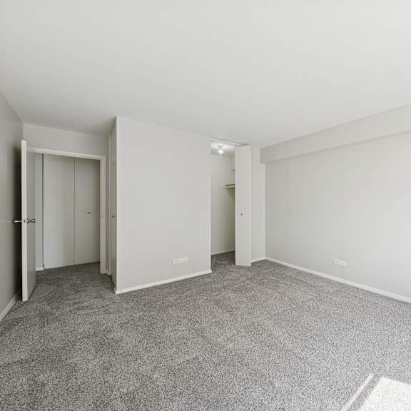 a room with a grey carpet and white walls.