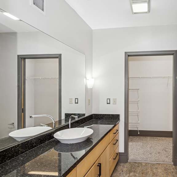 a bathroom with a sink, mirror, and shower.