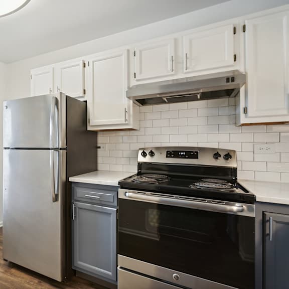 a kitchen with white cabinets and stainless steel appliances at the hinsdale, illinois, 60521