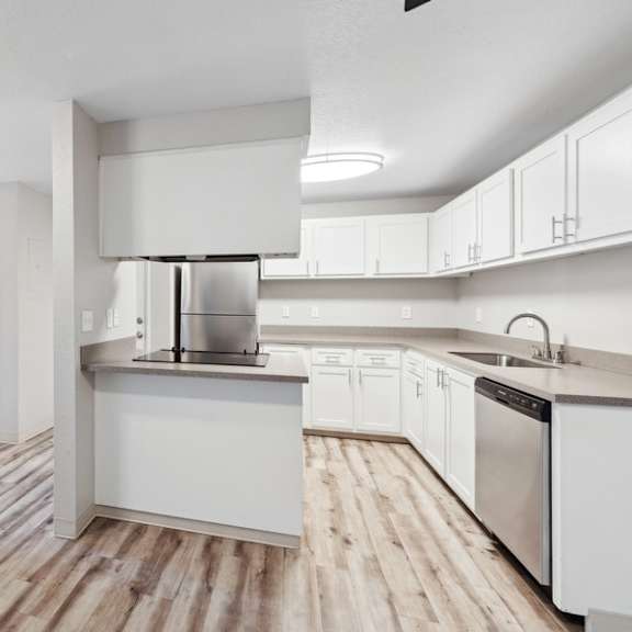 a large white kitchen with white cabinets and stainless steel appliances at sundial apartments, wilsonvile, oregon