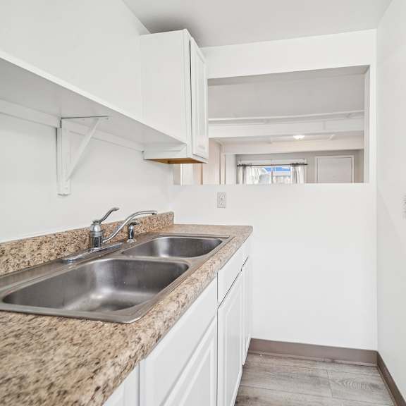 a kitchen with a granite countertop and white cabinets.