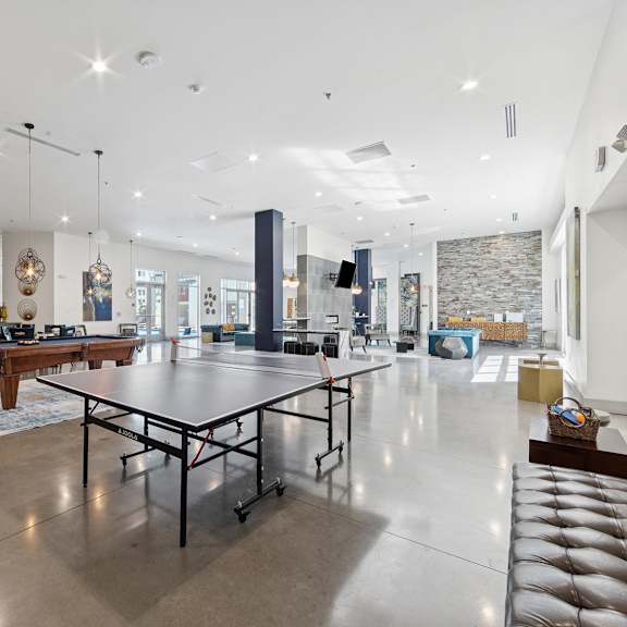 a spacious room with a pool table and table tennis setup