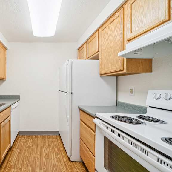 a kitchen with wooden cabinets and a white refrigerator.