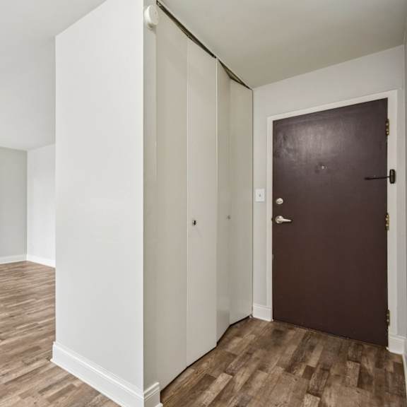 a room with a brown door and wooden floors.