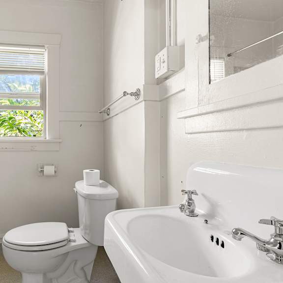 a bathroom with a toilet shower and sink.