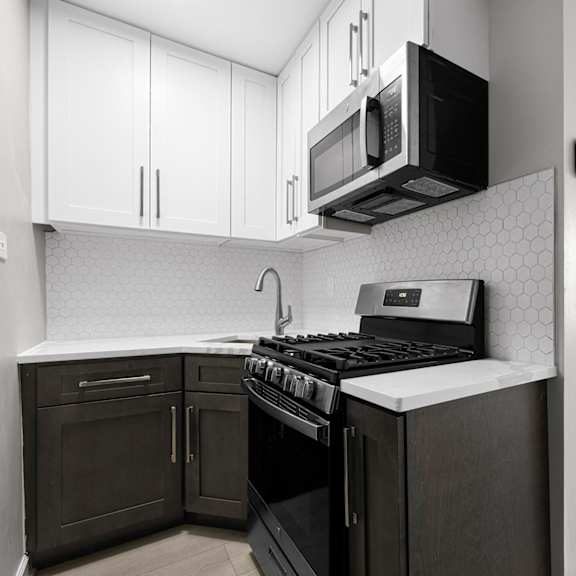 a kitchen with a black stove top oven and black microwave above it at pleasant oak apartments, illinois, 60302