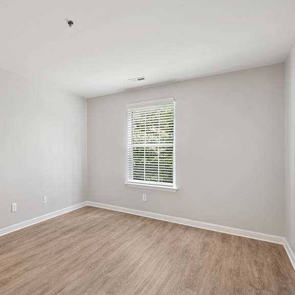 a room with a window and wooden flooring.