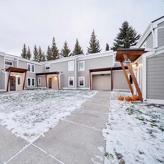 a row of houses with a snowy front yard.