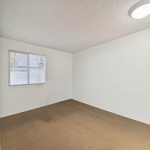 a room with a window and carpeted floor.