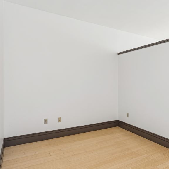 a room with white walls and a wooden floor.