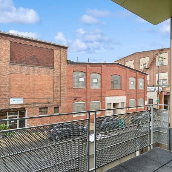 a balcony with a metal railing and a glass door.