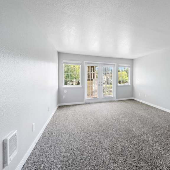 an empty living room with a door to a patio at sundial apartments, wilsonvile, oregon