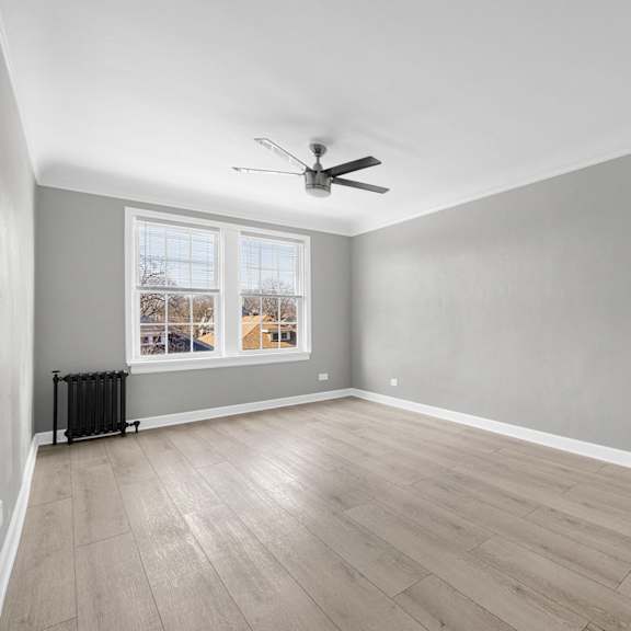 a room with a ceiling fan and a window with a view at pleasant oak apartments, oak park, 60302