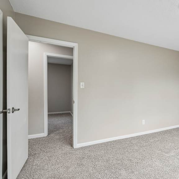 a room with a carpeted floor and a doorway leading to another room.