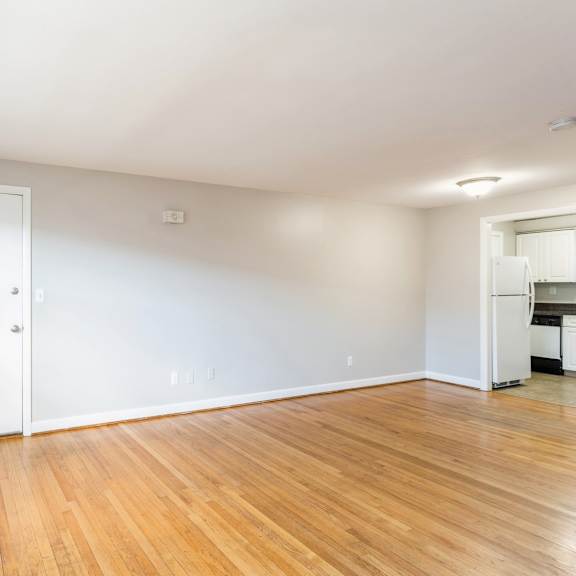 a living room with a wood floor and a white wall with geometric patterns on it