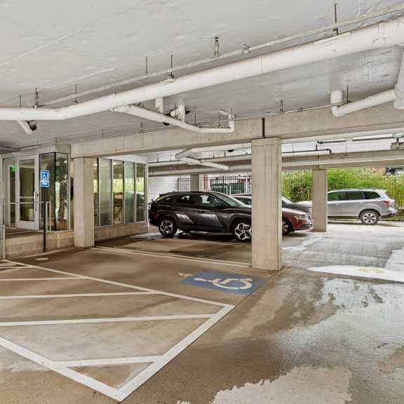 a parking garage with a car parked in a handicapped spot.