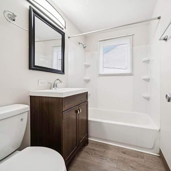 a white bathroom with a white toilet and a white bathtub.
