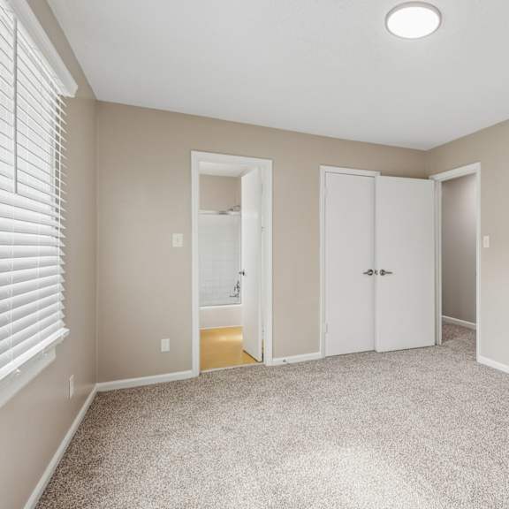 a room with a carpeted floor and two white doors.