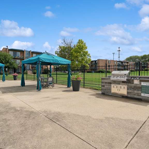 a playground with a green canopy and a sign on a wooden post.