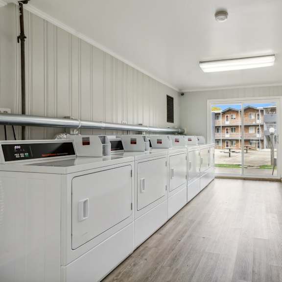 laundry room with washer and dryers and a door to a building in the at river oaks, north aurora, il, 60542
