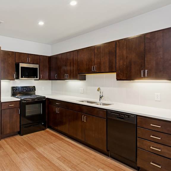 a kitchen with dark wood cabinets and a white counter top.