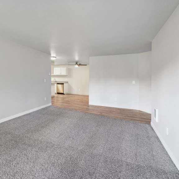 the living room and dining room of a house with white walls and carpet at sundial apartments, wilsonvile, oregon