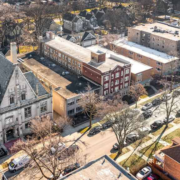 a large building with a tower is surrounded by other buildings at pleasant oak apartments, oak park, illinois