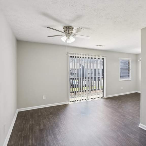 a room with a sliding door and a ceiling fan.