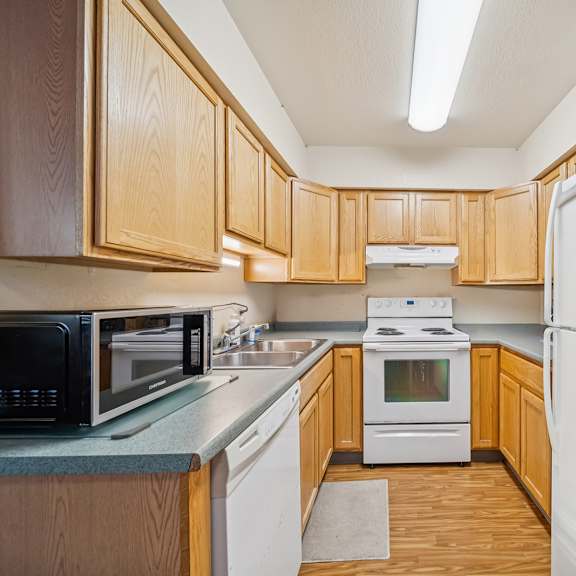 a kitchen with wooden cabinets and white appliances.