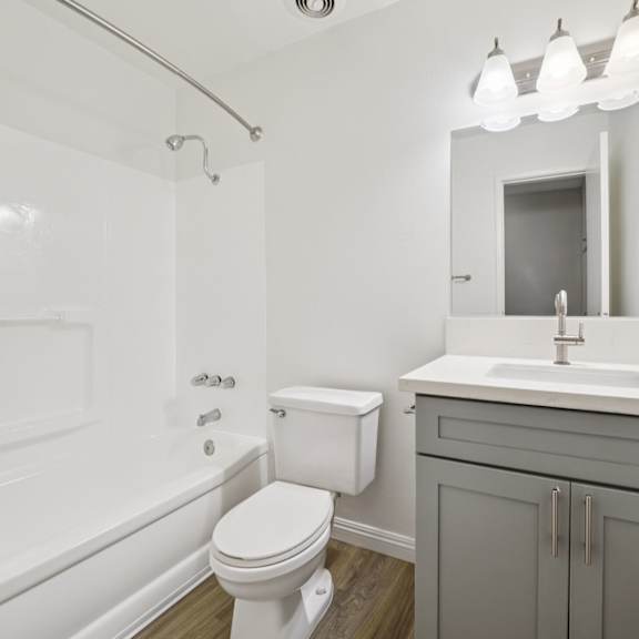 a white toilet sits next to a white sink in a bathroom.