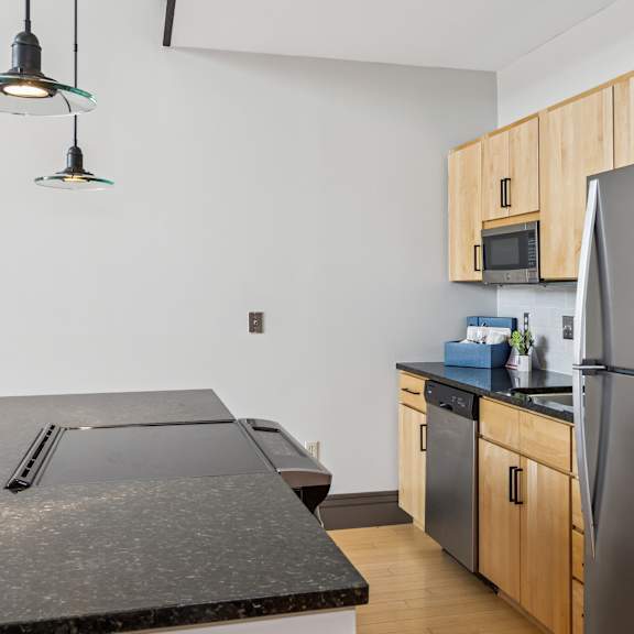 a kitchen with a black counter top and a black refrigerator.