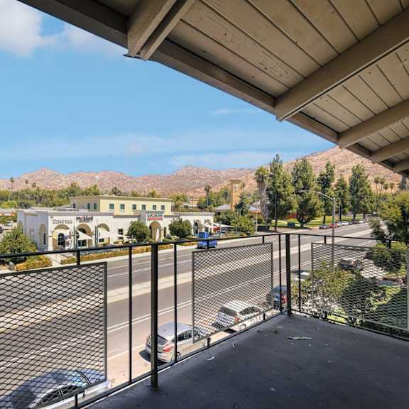 the view of the parking lot from the balcony of a building with a parking lot
