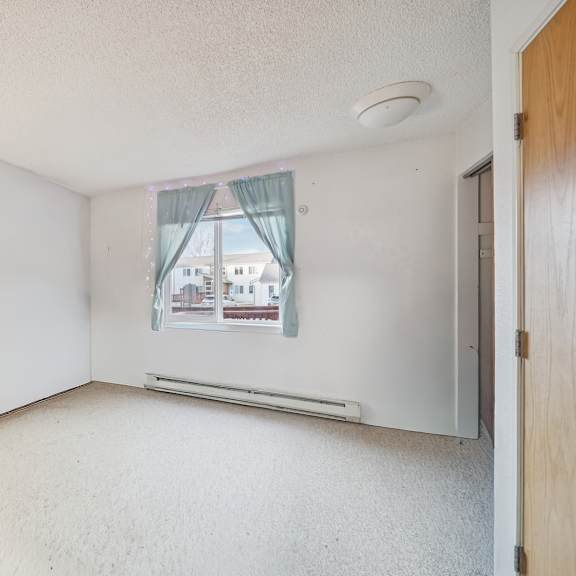 a room with a window showing a building outside.