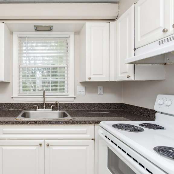a kitchen with white appliances and granite counter tops and white cabinets