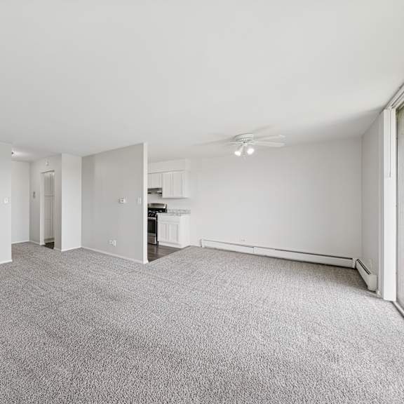 a spacious, empty room with grey carpeting and white walls.