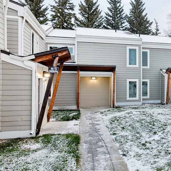 a row of houses with snow on the ground.