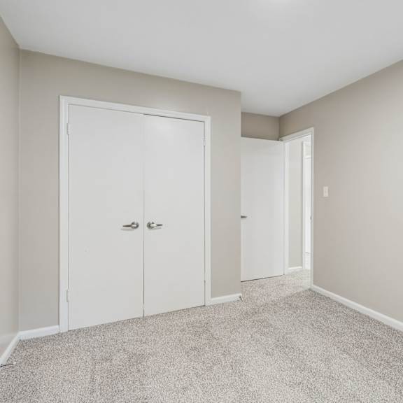 a room with two white doors and a carpeted floor.