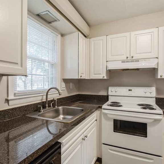 a kitchen with white appliances and granite counter tops