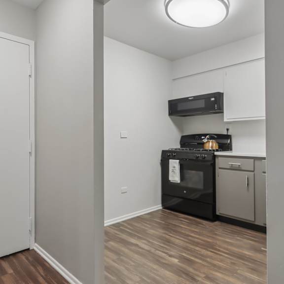 a white door is on the left and a black oven is on the right.