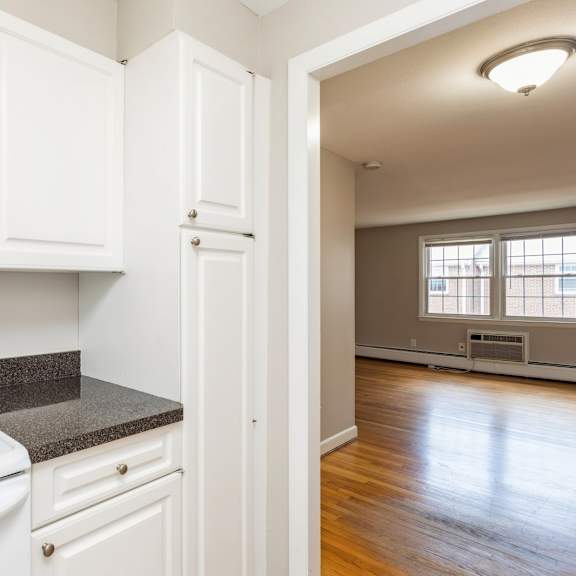 an empty kitchen with white appliances and white cabinets