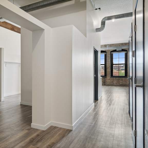 a large empty room with white walls and a wooden floor at gaar scott historic lofts, minneapolis, minnesota