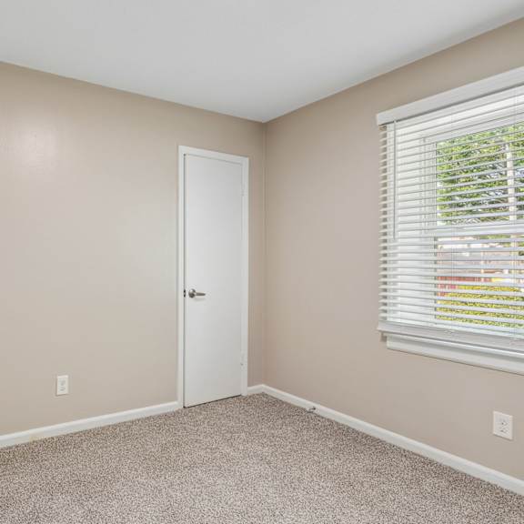 a room with a white door and a window with blinds.