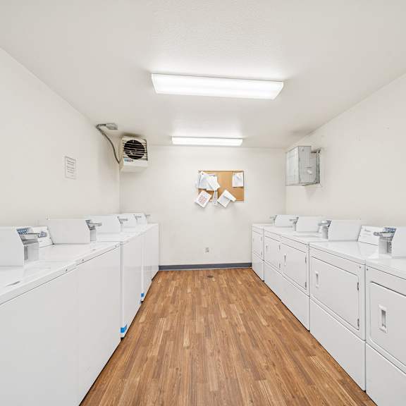 a laundromat with white washers and dryers.