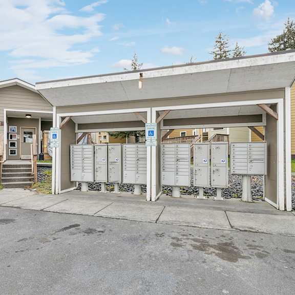 a parking lot in front of a building with a garage door open.