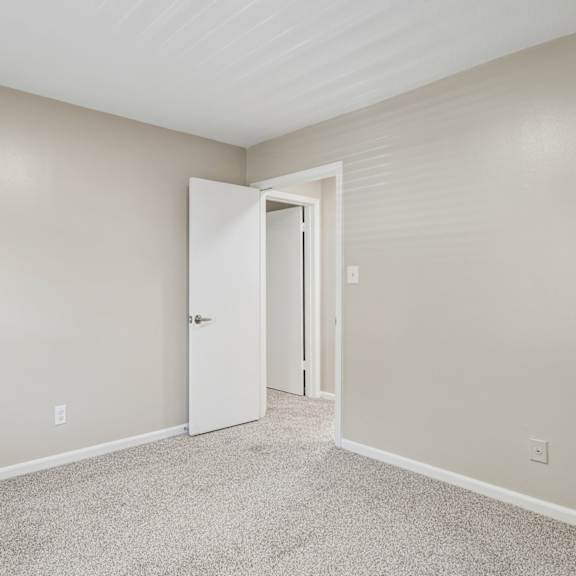 a room with a carpeted floor and a white door.