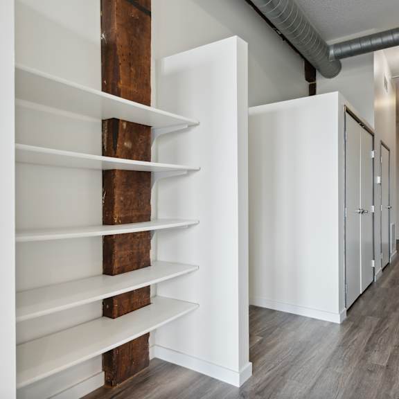 a walk in closet with white walls and wooden shelvesat gaar scott historic lofts, minneapolis, mn, 55401