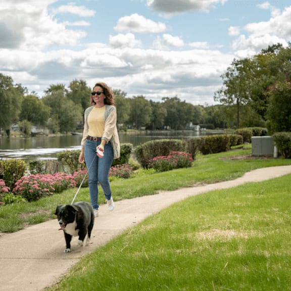 a woman walking her dog in a park at the view apartments st charles, illinois