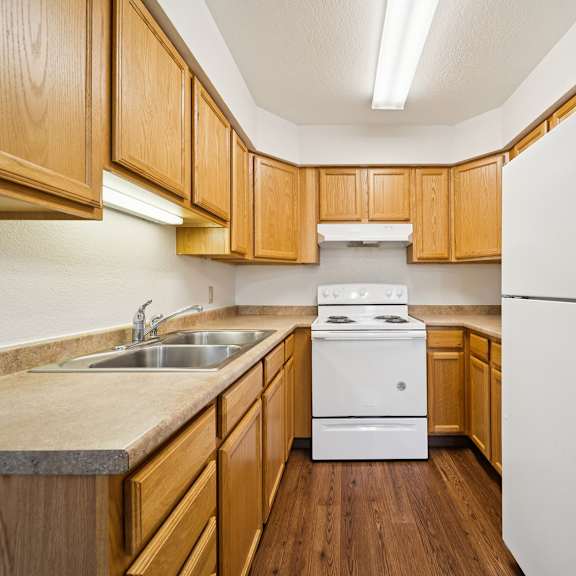 a kitchen with wooden cabinets and a white refrigerator.