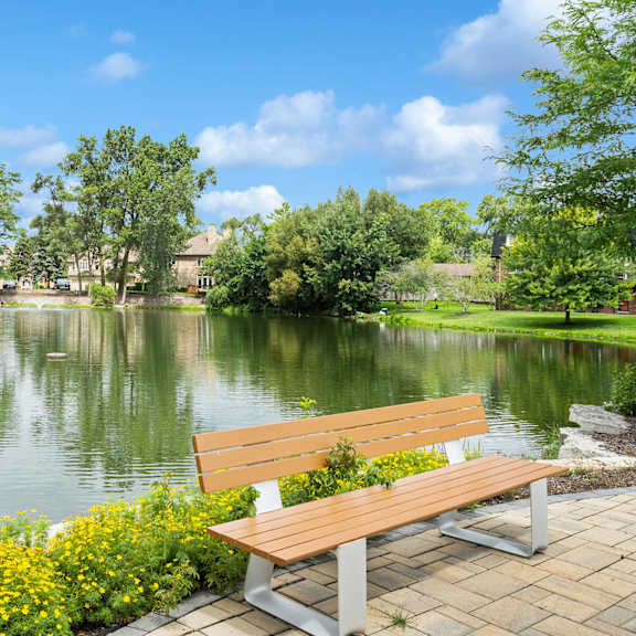 a bench overlooking a lake with houses and trees in the background at the hinsdale, illinois, 60521