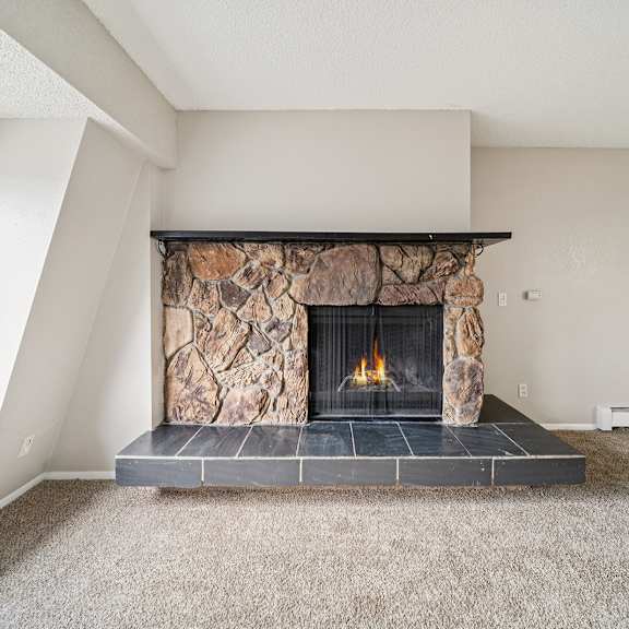a stone fireplace with a fire burning in it.